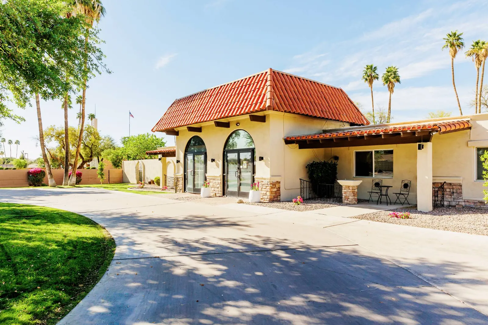 Front entrance with arched doors and a shaded drive