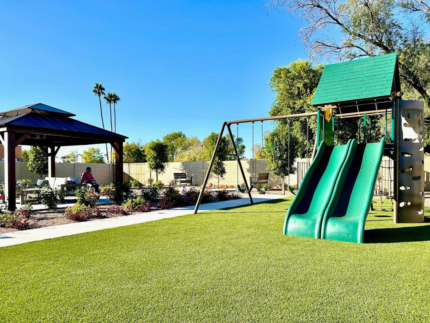 Lawn and play set for visiting grandchildren, with a resident relaxing in the gazebo